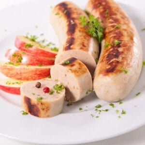 2 Cooked Boudin Blanc (white sausage) with apples on a plate